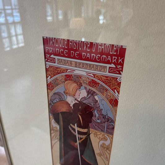 Decorative poster with intricate design and text on a plain wall.