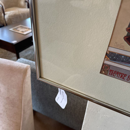 Framed artwork with a visible price tag on a wall in a room setting.