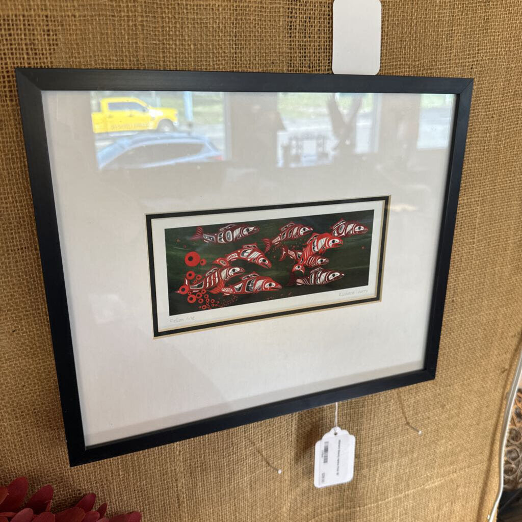 Framed artwork with a tag on a textured brown wall
