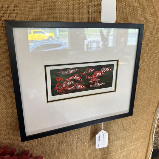 Framed artwork with a tag on a textured brown wall