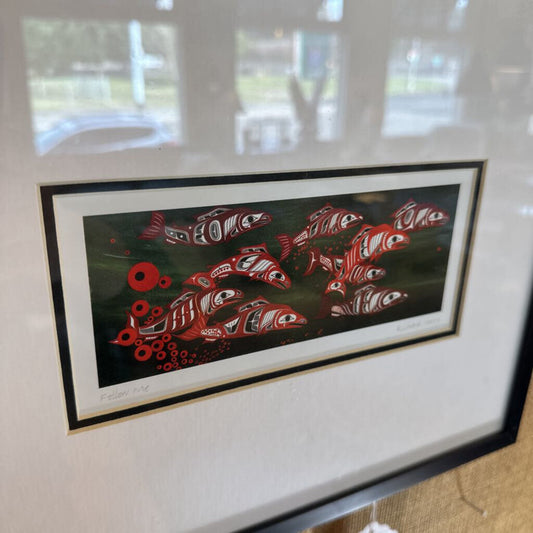 Framed artwork of red fish on a black background