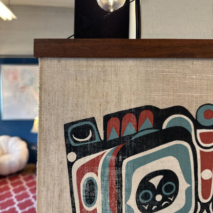 Framed artwork with a stylized face design on a textured background