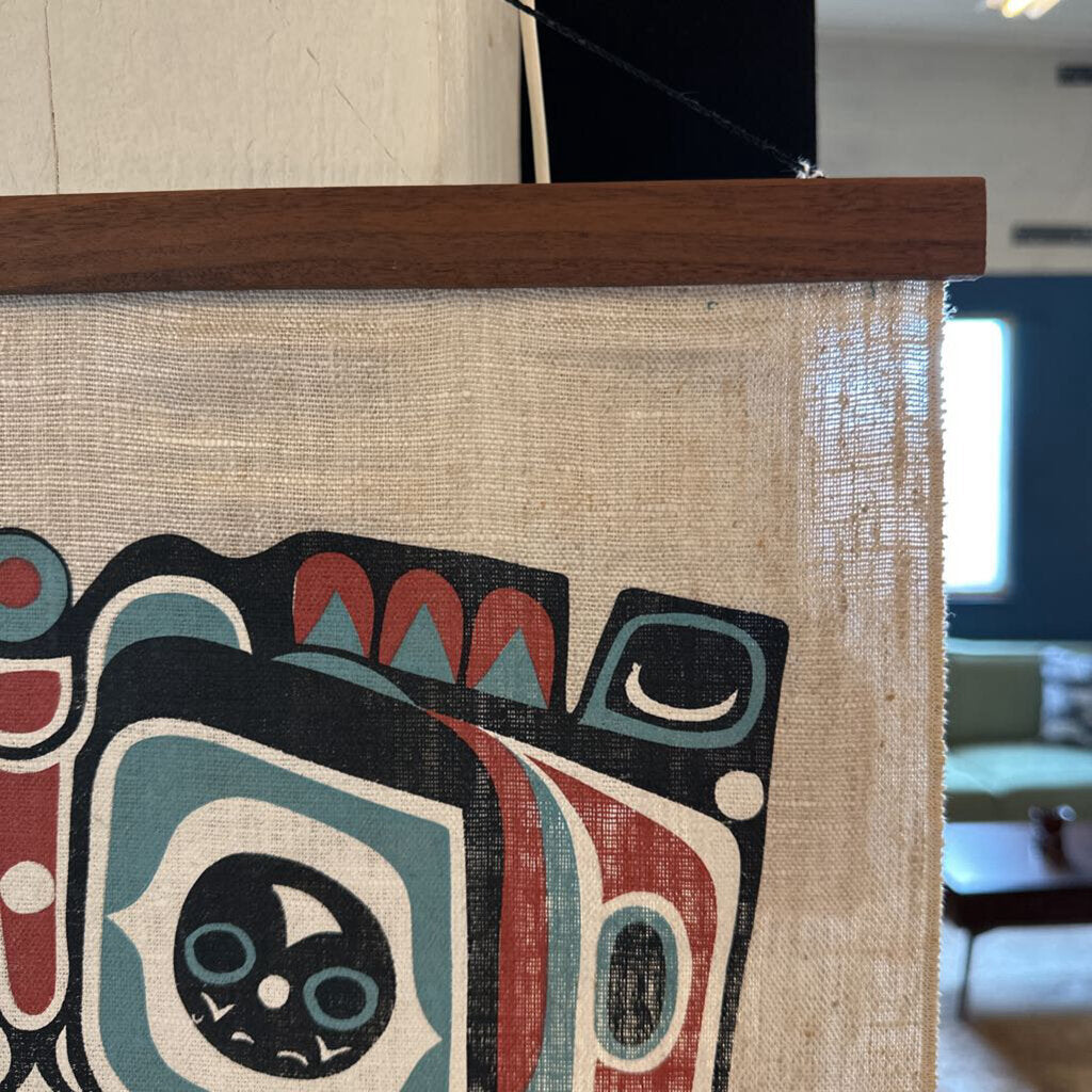 Decorative wall art with a colorful abstract design on a textured surface, framed by a wooden border.