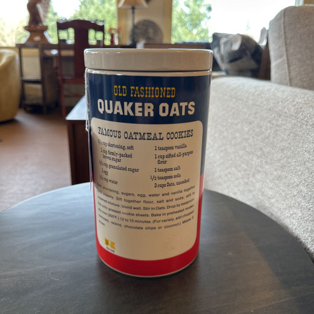 Canister of Old Fashioned Quaker Oats on a table in a room with furniture.