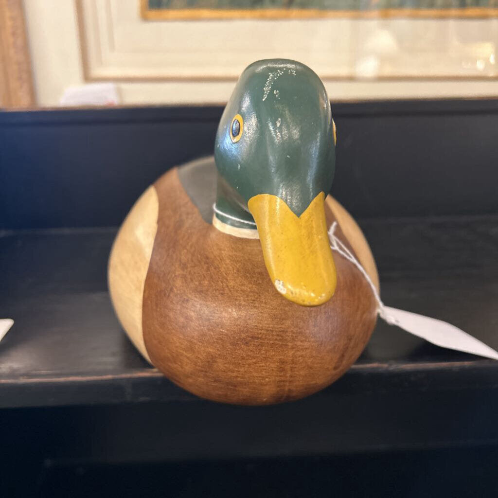 Wooden duck decoration on a dark surface with a blurred background