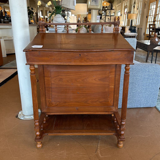 Wooden side table in a showroom setting with furniture and decor in the background