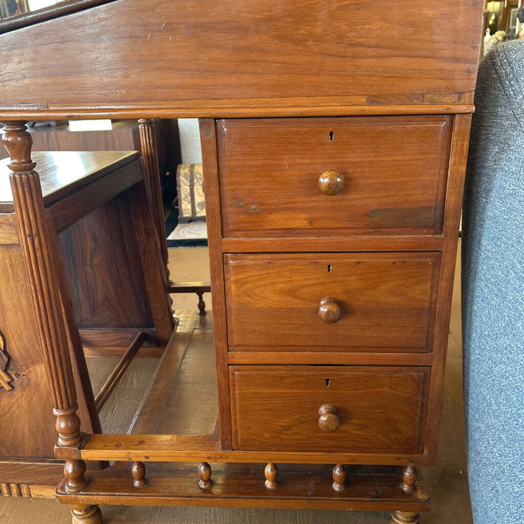 Wooden desk with drawers and a chair in the background