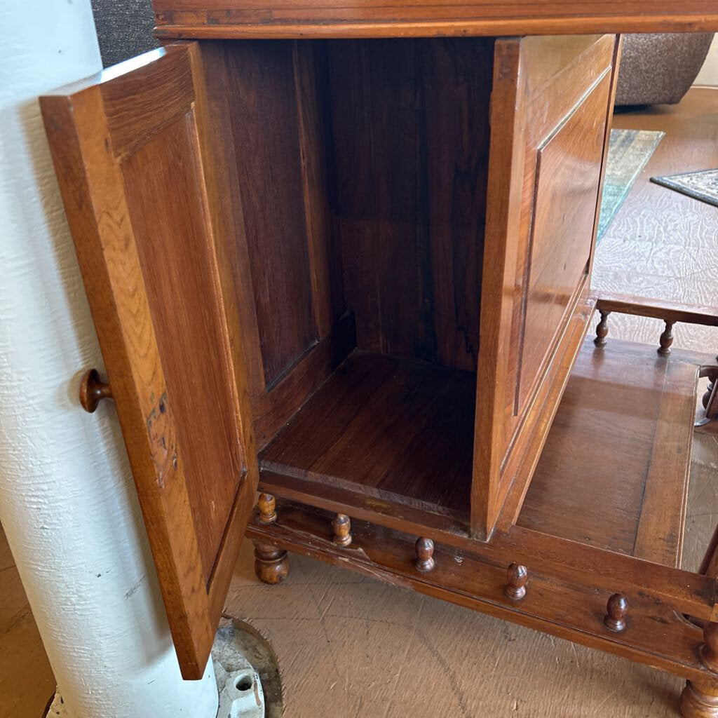 Wooden cabinet with open doors on a carpeted floor