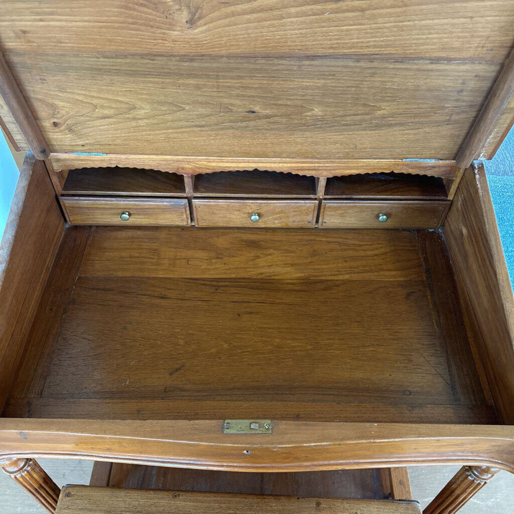 Wooden desk with open top drawer on a blue background
