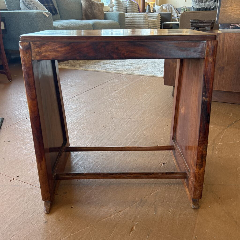 Wooden side table on a wooden floor with a blurred background