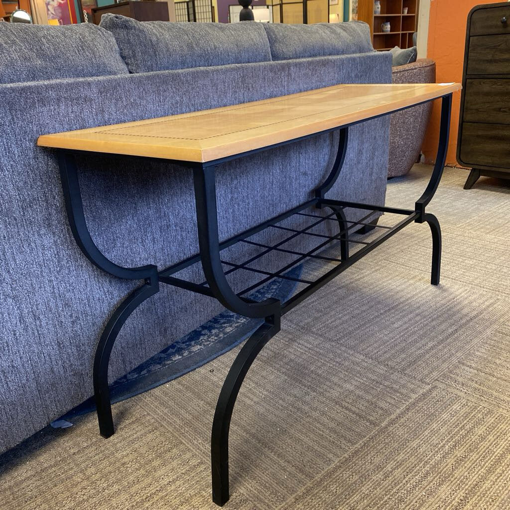 Wooden table with black metal legs in a room with blue upholstered chairs.
