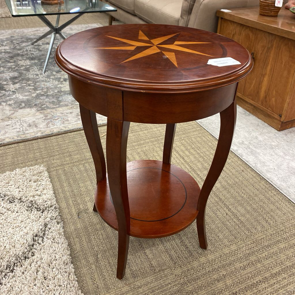 Wooden side table with star inlay on a carpeted floor