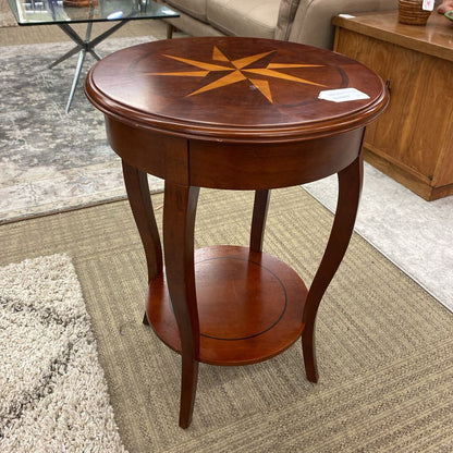 Wooden side table with star inlay on a carpeted floor
