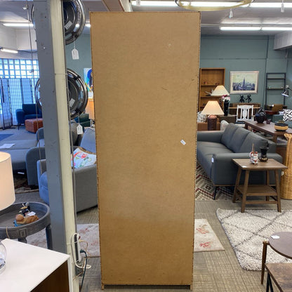 Cardboard panel in a furniture store with various items and decor in the background