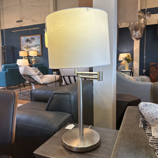 Table lamp with a white shade on a table in a living room setting