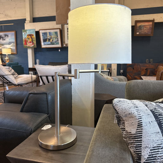 Table lamp on a coffee table with a living room setting in the background