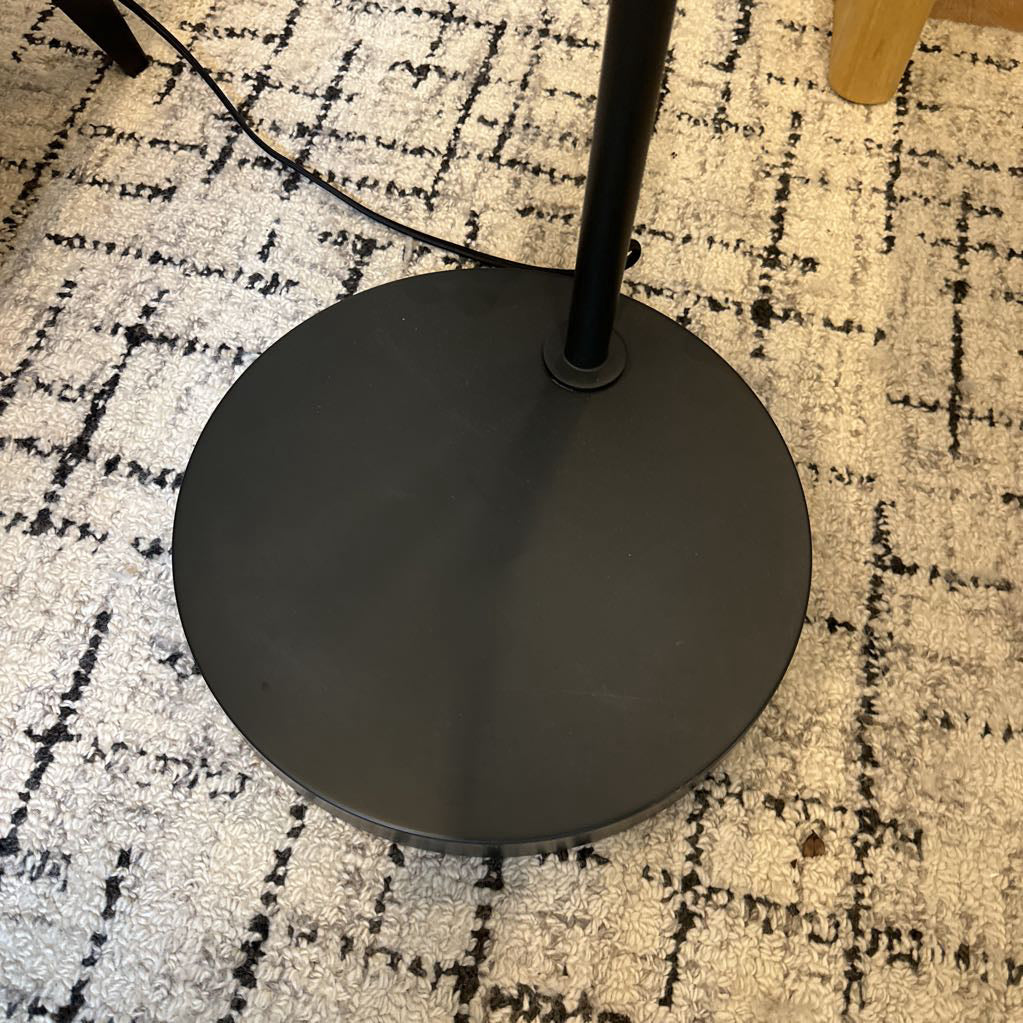 Black floor lamp base on a patterned carpet