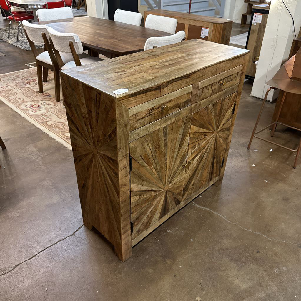 Wooden cabinet with starburst pattern in a showroom setting