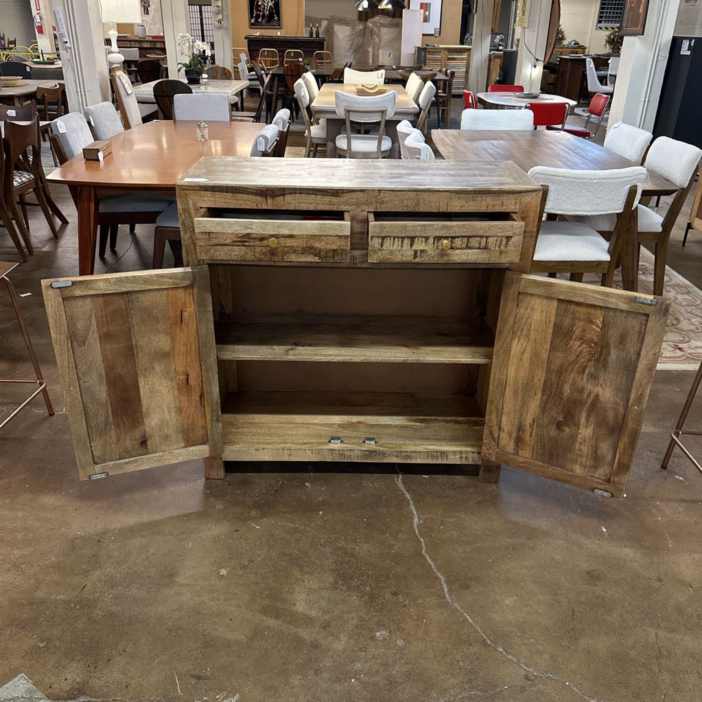 Wooden kitchen island with open doors in a showroom setting