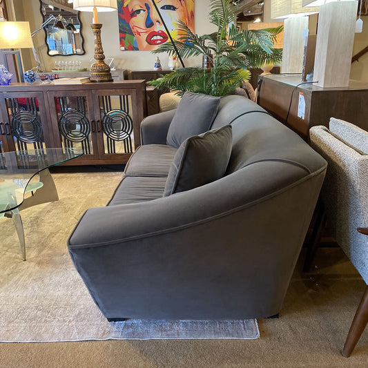 Gray sofa in a room with decorative elements and furniture.