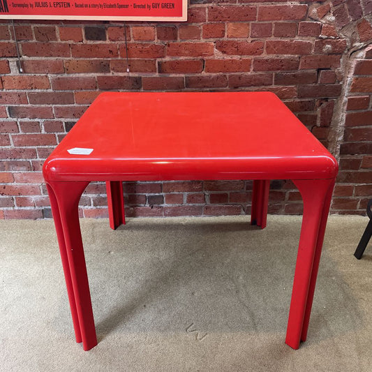 Red table against a brick wall