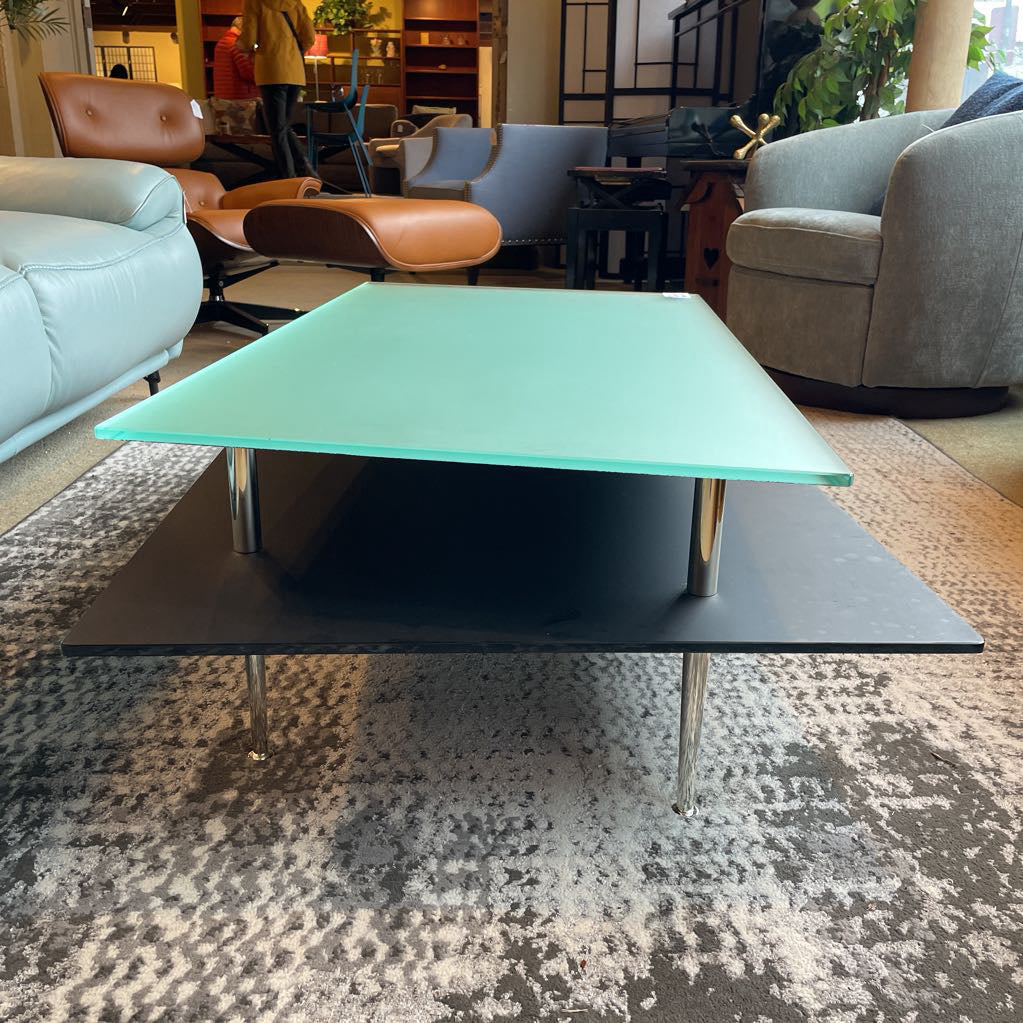 Modern coffee table with green glass top in a living room setting