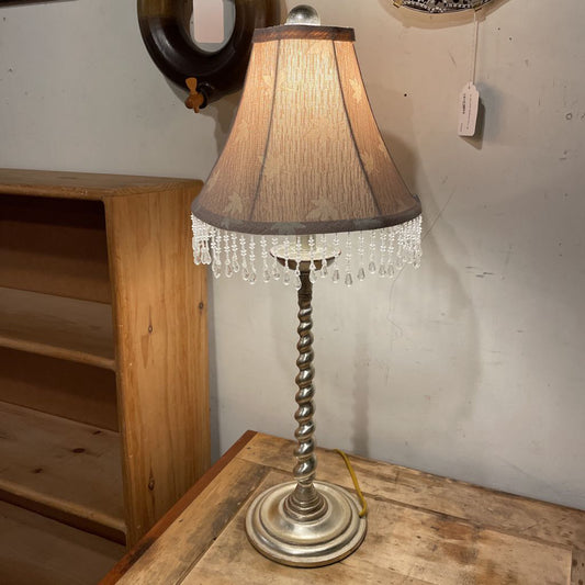 Decorative lamp with a textured shade on a wooden surface