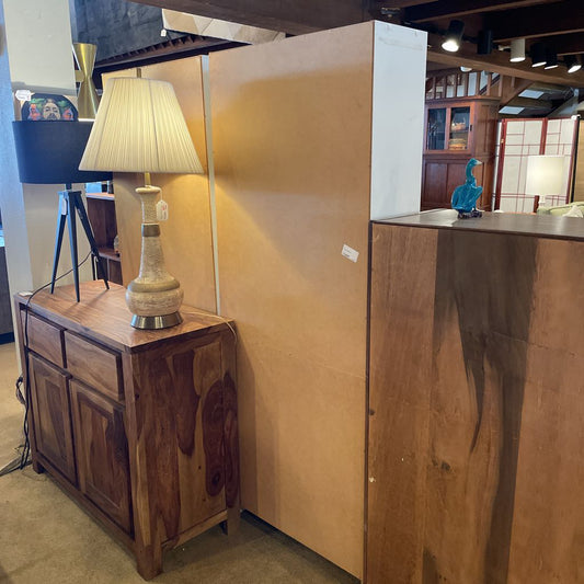 Wooden cabinet with a lamp on top in a room setting