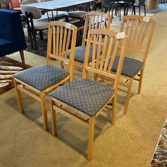 Set of wooden chairs with patterned cushions on a carpeted floor