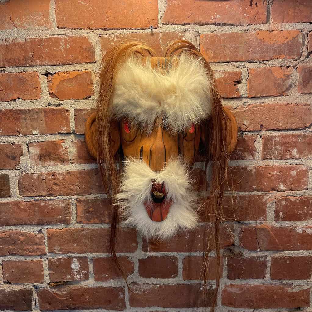 Lion head mask on a brick wall