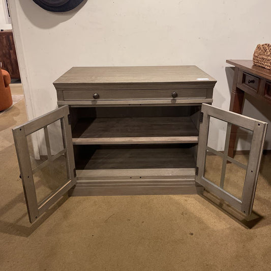 Wooden sideboard with open doors in a room setting