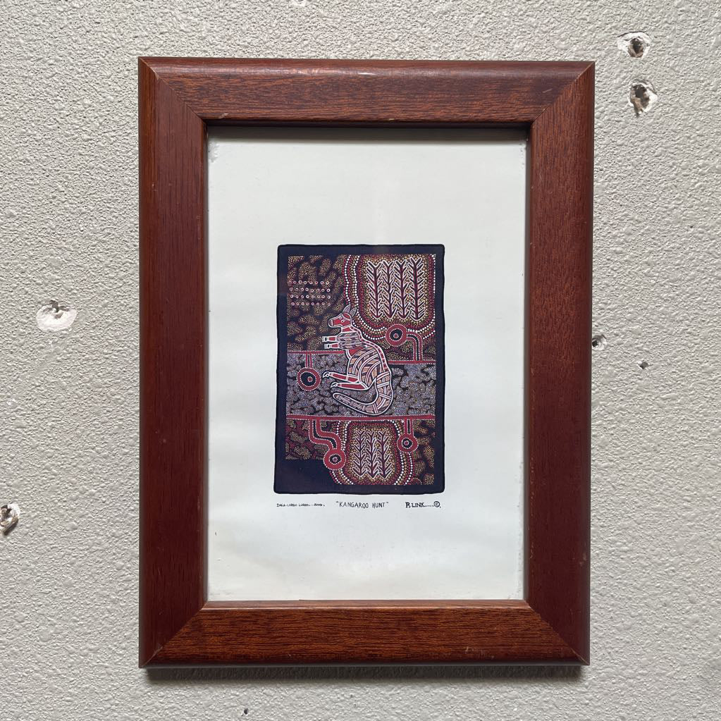 Framed textile art piece on a textured wall