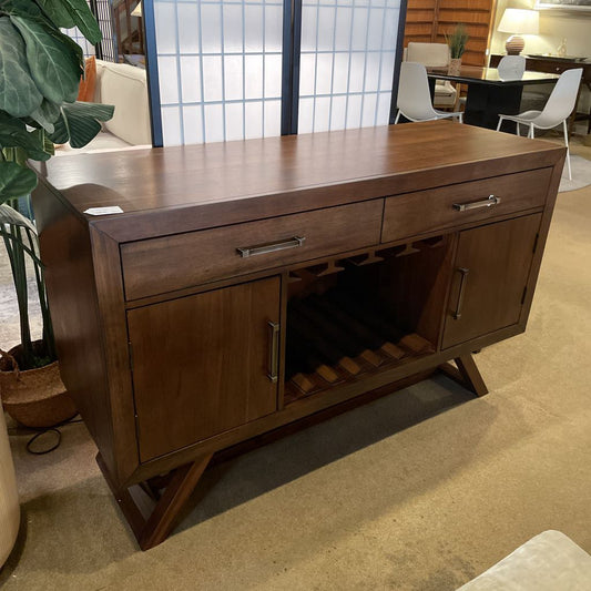 Wooden sideboard with drawers and cabinet doors in a room setting.