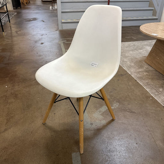 White chair with wooden legs on a concrete floor