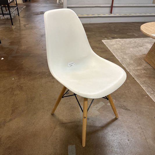White chair with wooden legs on a concrete floor