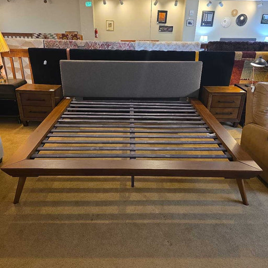 Wooden bed frame with slats in a room setting