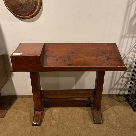 Wooden stool against a plain wall