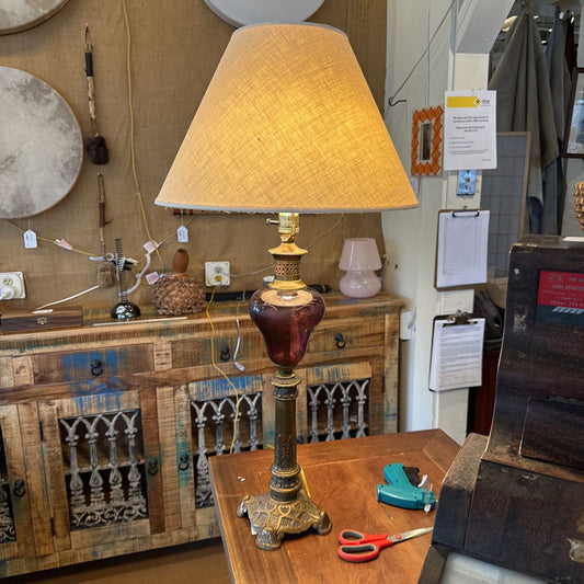 Decorative lamp on a wooden table with various items in the background