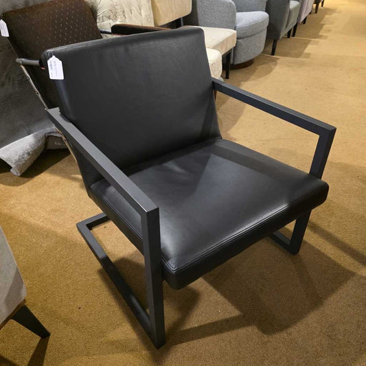 Black chair with gray cushion on a brown carpeted floor