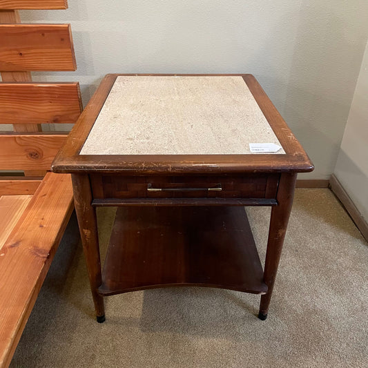 Wooden side table with marble top in a room setting