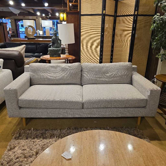 Gray sofa in a room with a rug and table