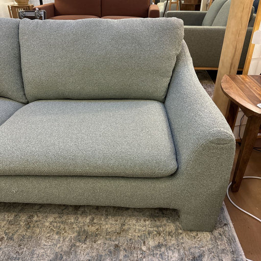 Gray sofa in a room with a wooden table and other furniture.