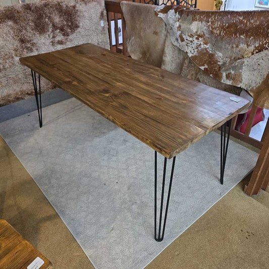 Wooden table with metal legs on a gray rug