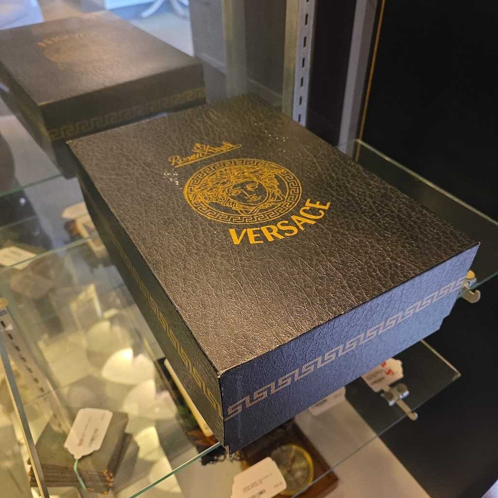 Versace box on display in a store with a blurred background