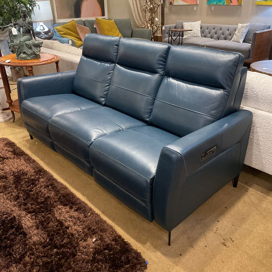 Blue leather sofa in a showroom with other furniture.