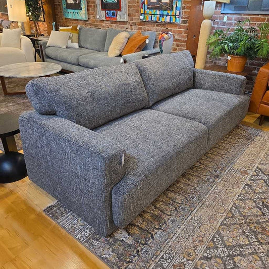 Gray sectional sofa in a living room setting with decor elements.