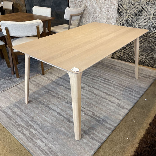 Wooden dining table with chairs on a gray rug