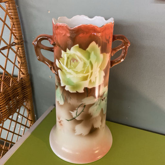 Decorative vase with floral design on a green surface