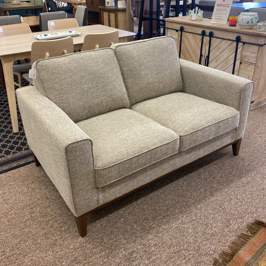 Gray fabric sofa in a room with tables and chairs