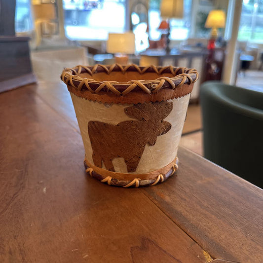 Decorative pot with moose design on a wooden surface